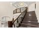 Elegant staircase with marble steps, wrought iron railing, and chandelier lighting at 2146 Greensward Ne Dr, Atlanta, GA 30345