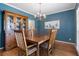 Elegant dining room with blue walls, a wooden table, and a china cabinet for a sophisticated dining experience at 2986 Sedgewick Pl, Marietta, GA 30062