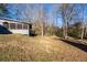 Backyard view of the home's exterior, adjacent wooded area and play structure at 217 Woodglen Dr, Woodstock, GA 30188