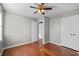 Bedroom with hardwood floors, neutral gray walls, ceiling fan, and two closets with white doors at 217 Woodglen Dr, Woodstock, GA 30188