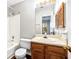 Full bathroom with a shower-tub combo, wood vanity, and shuttered storage, with a large mirror at 1017 Dover Way, Norcross, GA 30093