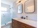 Modern bathroom featuring double mirrors, sleek wood cabinets, and a glass-enclosed shower at 1101 United Se Ave, Atlanta, GA 30316