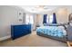 Cozy bedroom with a large blue dresser, twin bed, and carpeted floors bathed in warm sunlight at 1101 United Se Ave, Atlanta, GA 30316