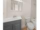 The bathroom features gray vanity, tile surround, updated fixtures, and laminate wood flooring at 130 Valley Rd, Stockbridge, GA 30281