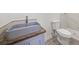 Bathroom featuring a modern vanity with grey granite countertop, toilet and tile shower at 130 Valley Rd, Stockbridge, GA 30281