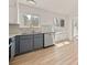 Bright kitchen features gray cabinets, stainless appliances, granite counters, and wood floors at 130 Valley Rd, Stockbridge, GA 30281