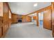 Spacious living room with stone fireplace, wood paneling, and a kitchenette area at 130 Valley Rd, Stockbridge, GA 30281