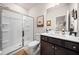 Bathroom featuring tiled shower, wood cabinets, neutral tones, and decorative accents at 169 Aspen Hall Dr, Canton, GA 30115