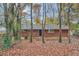 Back view of a brick house with leafy trees surrounding it at 8309 Dunellen Ln, Jonesboro, GA 30238