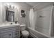 Full bathroom featuring a shower-tub combo, a white vanity, updated fixtures, and a framed mirror at 8309 Dunellen Ln, Jonesboro, GA 30238