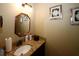 Cozy half bathroom with granite counter, decorative mirror and modern fixtures at 980 Yancey Ct, Loganville, GA 30052