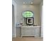 Hallway nook featuring elegant gray cabinetry, marble countertops, and an oval window with a view at 104 Grand Cres, Alpharetta, GA 30009