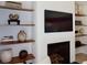 Modern living room featuring a sleek fireplace, a mounted television, and custom built-in shelving at 104 Grand Cres, Alpharetta, GA 30009