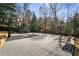 This fenced in backyard features a gray court, a basketball hoop and a trampoline for outdoor fun and activities at 18 Blackland Nw Rd, Atlanta, GA 30342