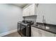 Modern laundry room with gray countertops, stainless steel sink, and sleek washer and dryer at 18 Blackland Nw Rd, Atlanta, GA 30342