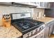 Stainless steel gas range with granite countertops and dark cabinetry creates a modern, functional kitchen space at 2145 Old Georgian Nw Ter, Atlanta, GA 30318