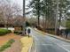 Gated entrance to a community with a brick guard house and mature trees at 25108 Plantation Dr # 108, Atlanta, GA 30324