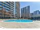 Apartment complex pool with lounge chairs and tall buildings at 44 Peachtree Nw Pl # 829, Atlanta, GA 30309