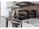 Close-up of the stove top with modern backsplash and granite countertops at 44 Peachtree Nw Pl # 829, Atlanta, GA 30309