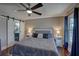 Main bedroom featuring a ceiling fan, hardwood floors, and barn door access to bathroom at 452 Springfield Dr, Woodstock, GA 30188