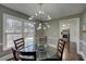 Bright dining room offers a modern light fixture, glass-top table, and a view into the adjacent kitchen at 452 Springfield Dr, Woodstock, GA 30188