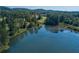 Scenic aerial view showcasing a tranquil lake surrounded by lush greenery and trees at 6525 Oak Highlands Ct, Cumming, GA 30041