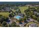 Aerial view of a community pool, clubhouse, and well-maintained landscaping at 6525 Oak Highlands Ct, Cumming, GA 30041