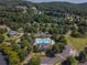 Aerial view of a community pool, clubhouse, and surrounding lush greenery at 6525 Oak Highlands Ct, Cumming, GA 30041