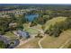Scenic aerial view featuring a home, a golf course, and a serene pond at 6525 Oak Highlands Ct, Cumming, GA 30041