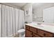 Well-lit bathroom with a shower-tub combo, wooden vanity, and neutral-toned walls and floors at 6525 Oak Highlands Ct, Cumming, GA 30041