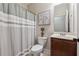 Bathroom featuring a shower with a curtain, a toilet, a sink with cabinet and decorative artwork at 6525 Oak Highlands Ct, Cumming, GA 30041
