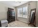 Bedroom with neutral walls, large window for natural light, and a dresser with a TV at 6525 Oak Highlands Ct, Cumming, GA 30041