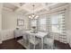 Chic dining room boasting dark wood floors, white trim, and large window overlooking manicured outdoor landscape at 6525 Oak Highlands Ct, Cumming, GA 30041
