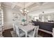 Elegant dining room featuring coffered ceilings, wainscoting, and stylish chandelier and seamless flow to living room at 6525 Oak Highlands Ct, Cumming, GA 30041