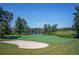 Scenic view of a golf course with a sand trap and a pond in the background at 6525 Oak Highlands Ct, Cumming, GA 30041