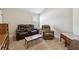 Carpeted living room featuring a plush leather reclining sofa, armchair, and decorative tables at 6525 Oak Highlands Ct, Cumming, GA 30041