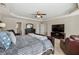 Large main bedroom with tray ceilings, seating, a king bed, carpet, dark furniture and plenty of natural light at 6525 Oak Highlands Ct, Cumming, GA 30041