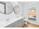 Bright bathroom with a dual vanity, wood look floors, and a window at 6800 Bells Landing Way, Rex, GA 30273