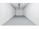 An empty garage featuring a garage door with gray flooring and white walls at 6800 Bells Landing Way, Rex, GA 30273