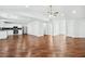 Spacious living area flowing into the kitchen, featuring hardwood floors, white walls, and modern lighting at 6800 Bells Landing Way, Rex, GA 30273