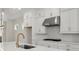 Elegant kitchen with stainless steel hood vent, marble countertops, and white cabinetry at 1929 Quarry Park Nw Pl, Atlanta, GA 30318