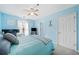 Light blue bedroom with a bed, ceiling fan, a desk, and two large windows at 330 Cottonwood Creek Cir, Canton, GA 30114