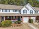 Charming townhome with brick accents, a covered porch, well-manicured landscaping, and attached garage at 330 Cottonwood Creek Cir, Canton, GA 30114