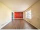 Open-concept living room with wood-look flooring and a red accent wall at 4023 Snapfinger Way, Decatur, GA 30035