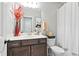 Well-lit bathroom with vanity, framed mirror, tub and shower with curtain at 10162 Windalier Way, Roswell, GA 30076