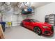 Well-organized garage featuring a red Audi, overhead storage, and epoxy flooring at 10162 Windalier Way, Roswell, GA 30076