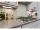 Well-equipped kitchen featuring a cooktop and custom backsplash at 10162 Windalier Way, Roswell, GA 30076