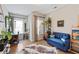 Cozy living room with hardwood floors, bright windows, work desk, and blue futon couch at 10162 Windalier Way, Roswell, GA 30076