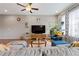 Cozy living room featuring hardwood floors, a comfortable gray sectional, and stylish decor at 10162 Windalier Way, Roswell, GA 30076