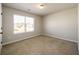 Bright bedroom with tan carpet and a large window overlooking the neighborhood at 103 Magnaview Dr, Mcdonough, GA 30253